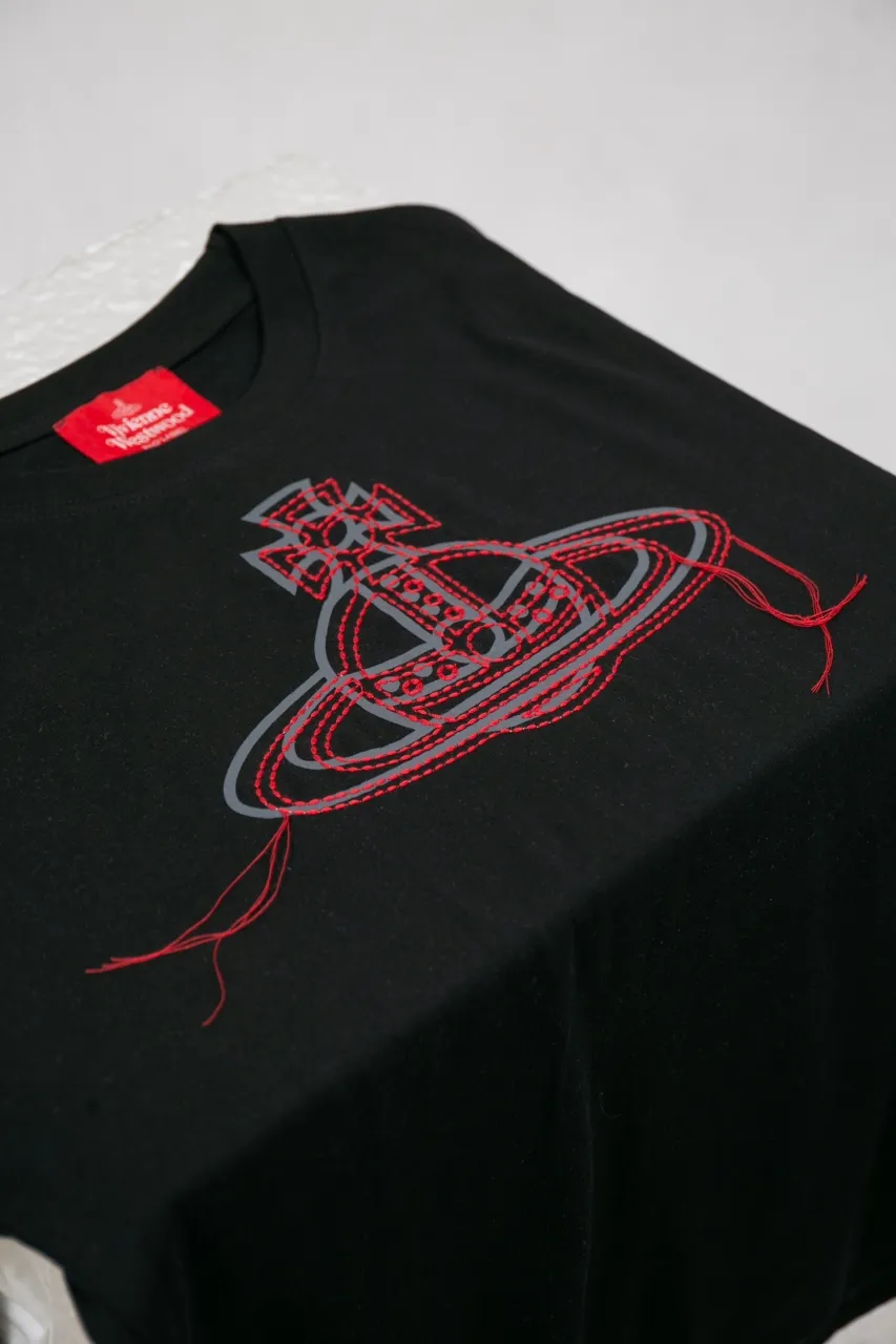 vivienne Westwood Queen Mother's new 2025 spring and summer Japanese limited-edition tassel embroidered short-sleeved T-shirt. The appearance of the appearance reveals the uninhibited image and high street trends. It has a loose and casual style, a short front and long back design, a small slit on the hem on both sides, and the iconic Saturn shape on the chest. The cross crown ball is added with a very futuristic satellite ring, just like Saturn, which collides with the prominent colors of the clothes. The non-overlapping Saturn pattern is outlined with red embroidery, which is visually dazzling. It also has a few tassels to complete the unconventional personality. 240g 32 count high-density double yarn cotton, comfortable and breathable fabric Size: XS-L Color: white, black